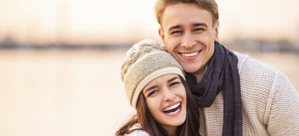 Loving young couple walk on the beach in autumn